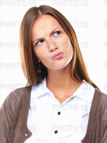 Close-up of business woman in doubt pursing her lips and looking away. Photo : momentimages