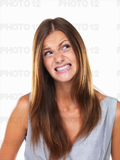 Beautiful woman with fake smile looking away. Photo: momentimages