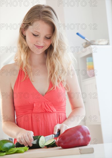 Young woman cutting vegetables. Photo : Jamie Grill