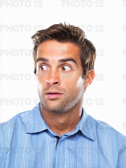 Studio portrait of surprised business man looking away. Photo : momentimages