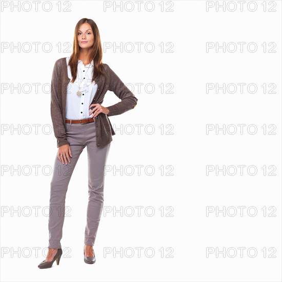 Studio shot of attractive sarcastic business woman standing with hand on hip. Photo : momentimages