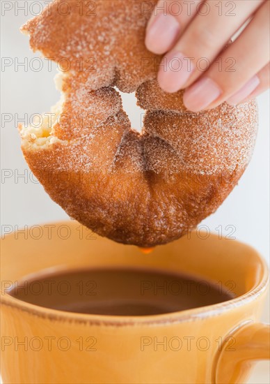 Close up of woman's hand holding donut. Photo : Jamie Grill