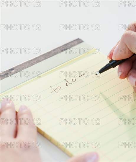 Close up of woman's hands writing list of things to do. Photo : Jamie Grill