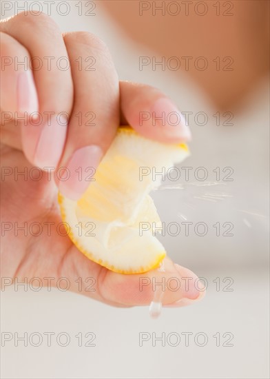 Close up of woman's hand squeezing lemon. Photo : Jamie Grill