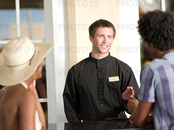 Couple checking in to hotel. Photo : db2stock