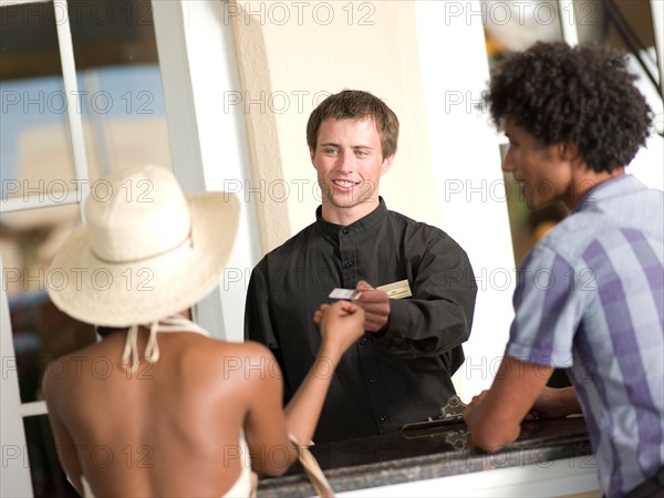 Couple checking in to hotel. Photo : db2stock