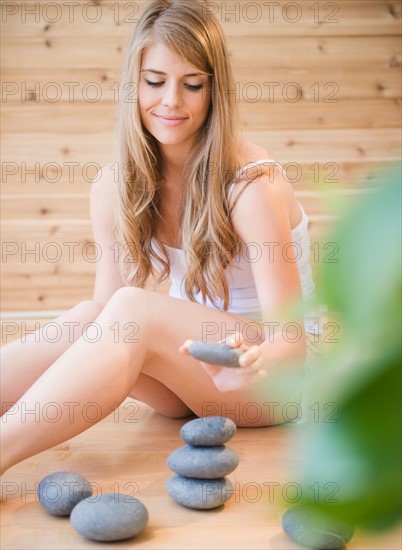 Woman arranging stones in spa. Photo : Jamie Grill