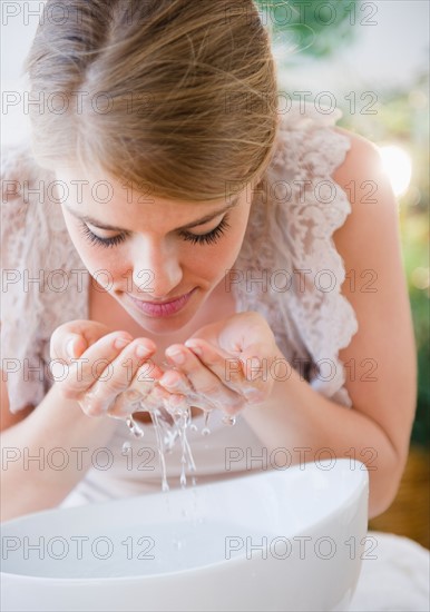 Woman washing face with water. Photo: Jamie Grill