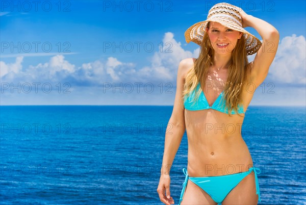 Woman wearing bikini by sea.