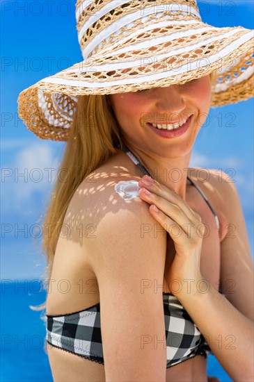 Woman applying sunscreen.