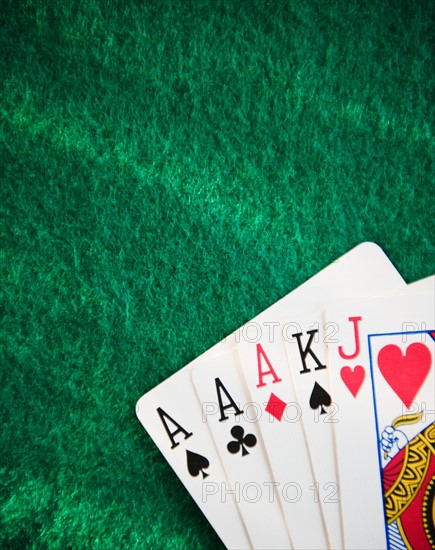 Close up of hand of cards on green felt. Photo : Jamie Grill