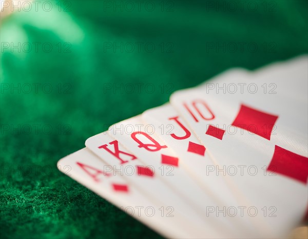 Close up of hand of cards on green felt. Photo : Jamie Grill