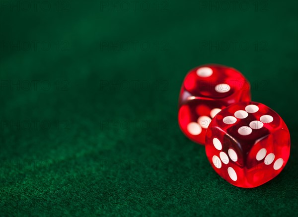 Close up of red dices on green felt. Photo : Daniel Grill