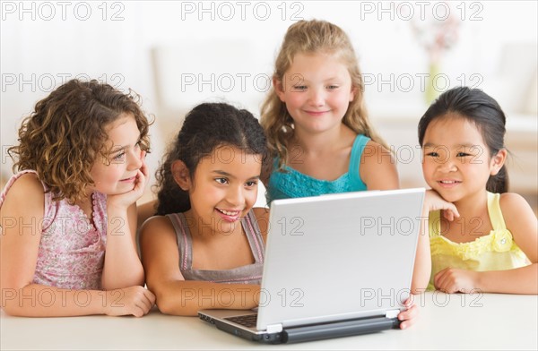 Four girls (6-9) using laptop.