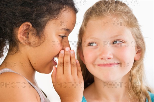 Two girls (8-9) whispering.