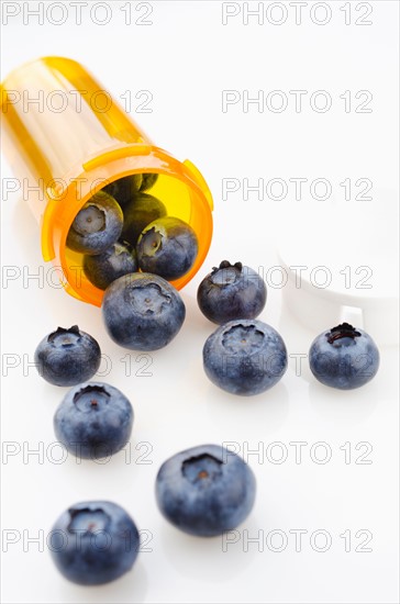 Blueberries spilling from prescription bottle.