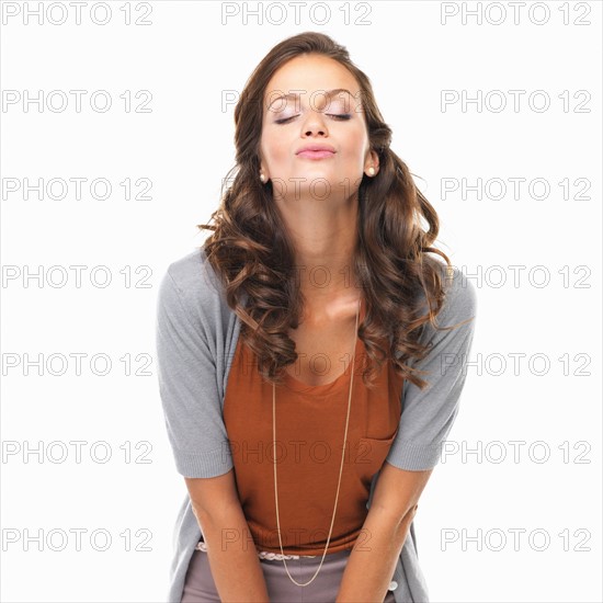 Studio portrait of beautiful woman giving a kiss. Photo : momentimages