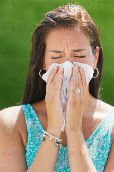 Woman blowing nose.