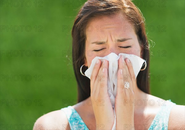 Woman blowing nose.