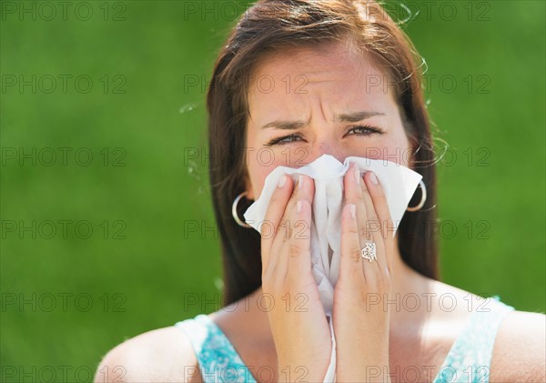 Woman blowing nose.