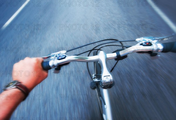 Hand gripping handlebar of bike.