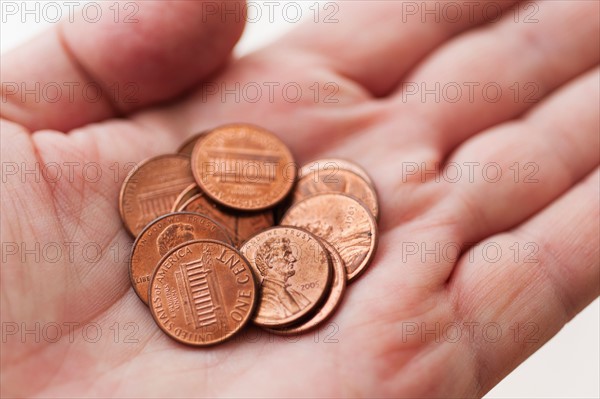 Male hand holding coins.