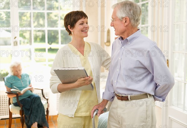 Senior man and nurse talking in nursing home.