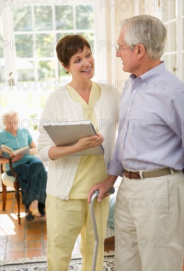 Senior man and nurse talking in nursing home.