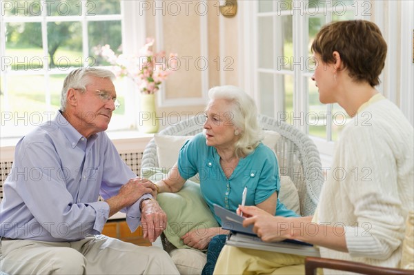 Nursing assistant talking with seniors in Nursing home.