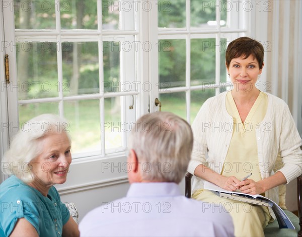 Nursing assistant talking with seniors in Nursing home.