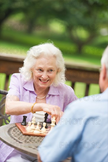 Seniors playing chess on porch.