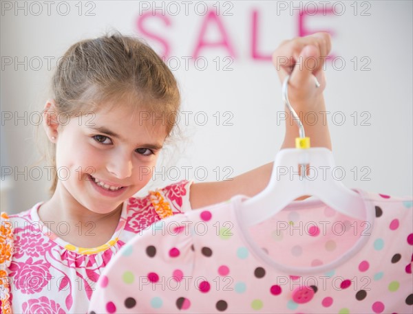 Girl ( 6-7) showing clothes while shopping. Photo : Jamie Grill