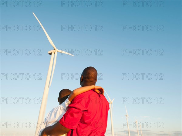 USA, Oregon, Wasco, Father and son (8-9) watching wind turbine.