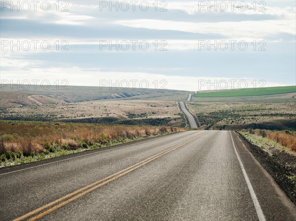 USA, Oregon, Boardman, Rolling landscape with empty road.