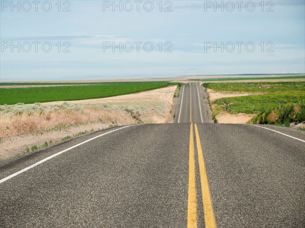 USA, Oregon, Boardman, Rolling landscape with empty road.