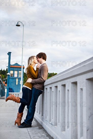 Young couple kissing on bridge. Photo: Take A Pix Media
