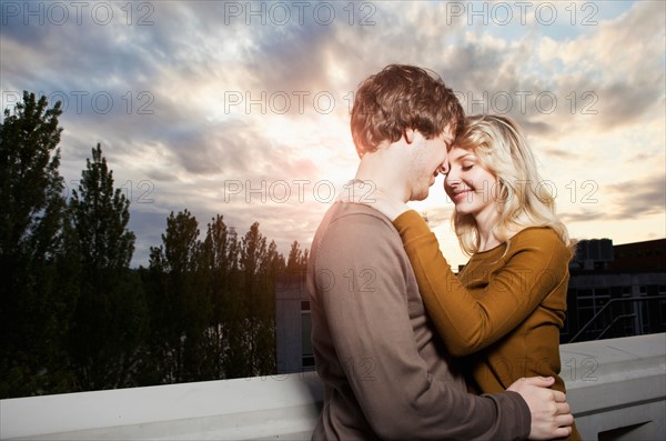 Young couple embracing under sunset sky. Photo : Take A Pix Media