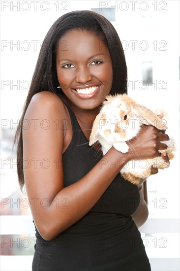 Portrait of young woman holding bunny. Photo : Pauline St.Denis