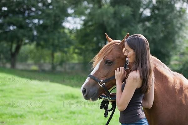 Young woman with horse in field. Photo : Jan Scherders