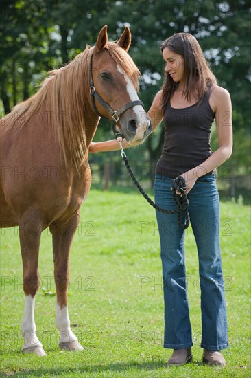 Young woman with horse in field. Photo : Jan Scherders