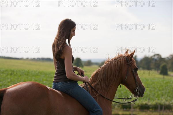 Young woman riding horse. Photo : Jan Scherders