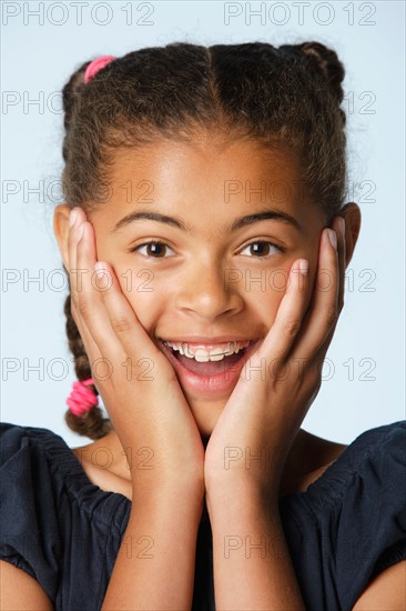 Studio portrait of girl (10-11) with head in hands. Photo : Rob Lewine