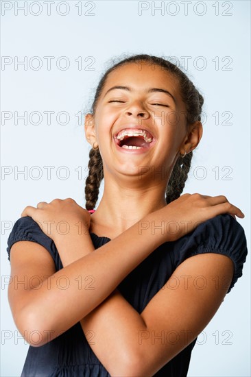 Studio portrait of girl (10-11) laughing. Photo : Rob Lewine