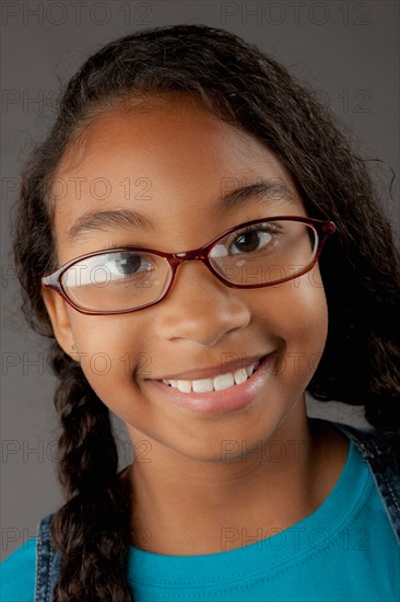 Studio portrait of girl (8-9) wearing eyeglasses. Photo : Rob Lewine