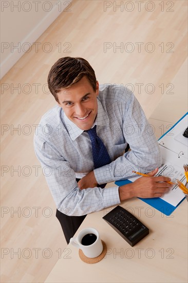 Portrait of young smiling businessman in office. Photo: Rob Lewine