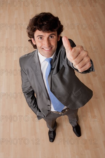 Portrait of mid adult businessman with thumb up. Photo : Rob Lewine