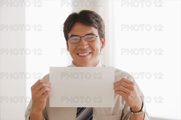 Business man holding blank paper. Photo: Rob Lewine