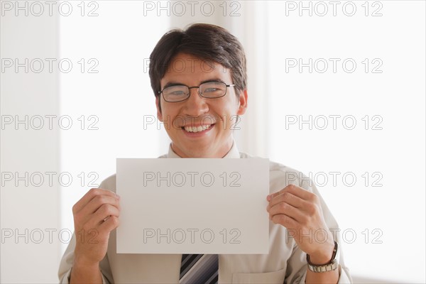 Business man holding blank paper. Photo : Rob Lewine