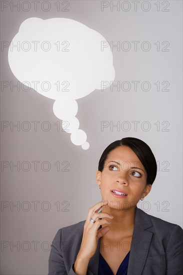 Studio shot of pensive business woman with speech bubble above head. Photo: Rob Lewine