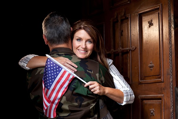 Soldier with wife embracing. Photo : db2stock